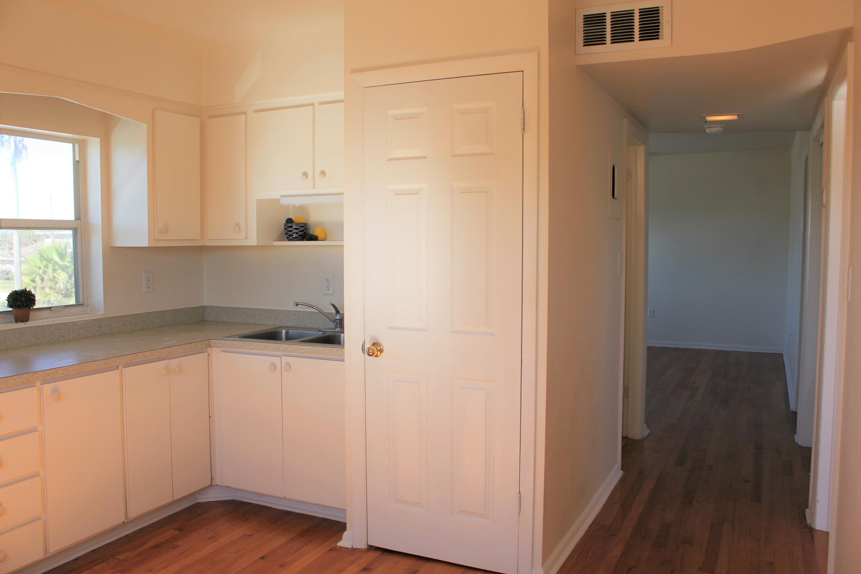 651 Palm Drive, Unit A4 Satellite Beach, FL 32937 - Photo 8 of 16 a kitchen with a refrigerator and white cabinets