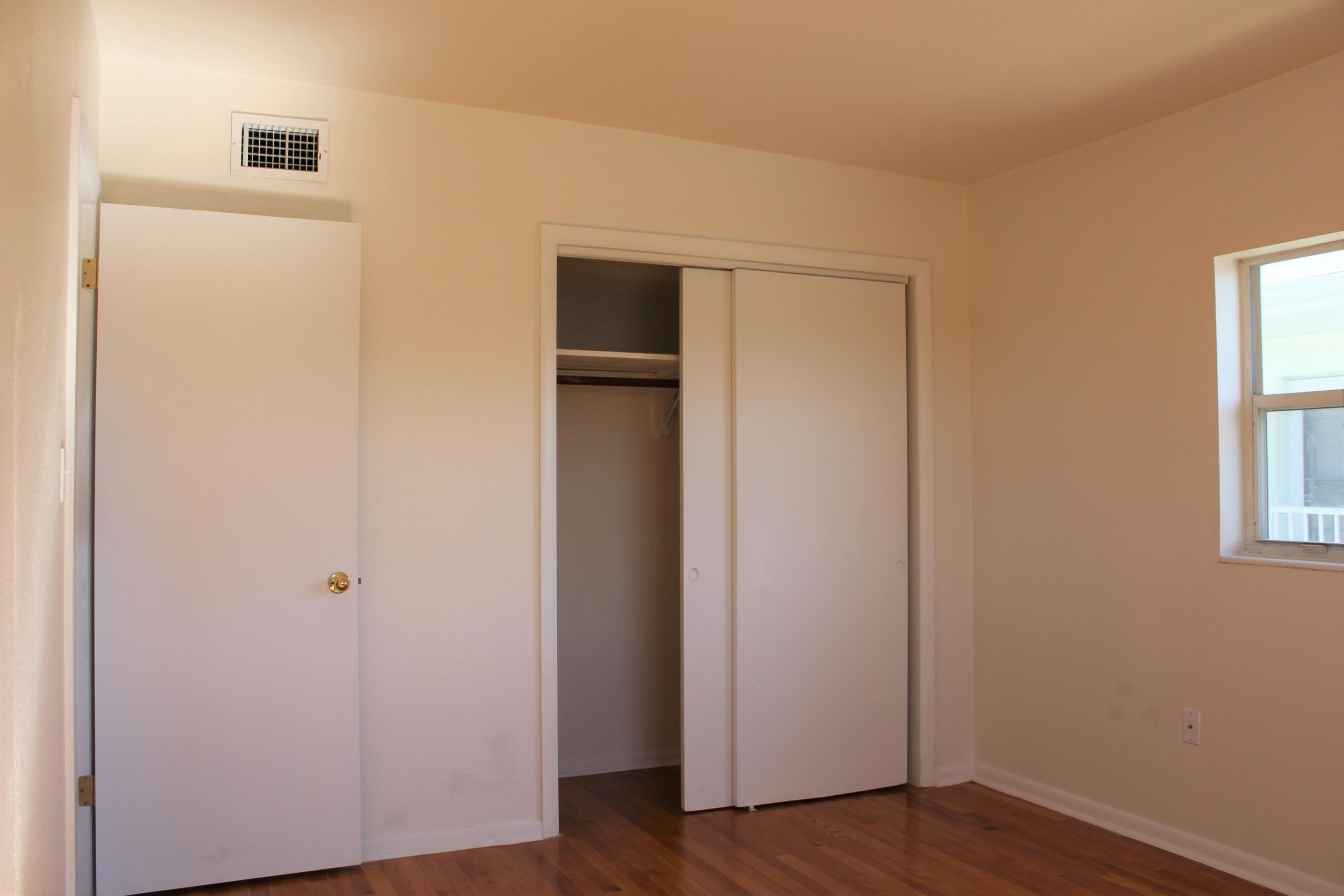 651 Palm Drive, Unit A4 Satellite Beach, FL 32937 - Photo 9 of 16 a view of an empty room with wooden floor and a window