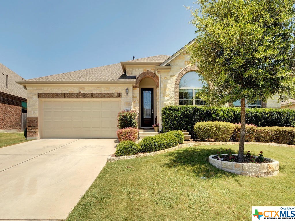 a front view of a house with a yard garage and outdoor seating