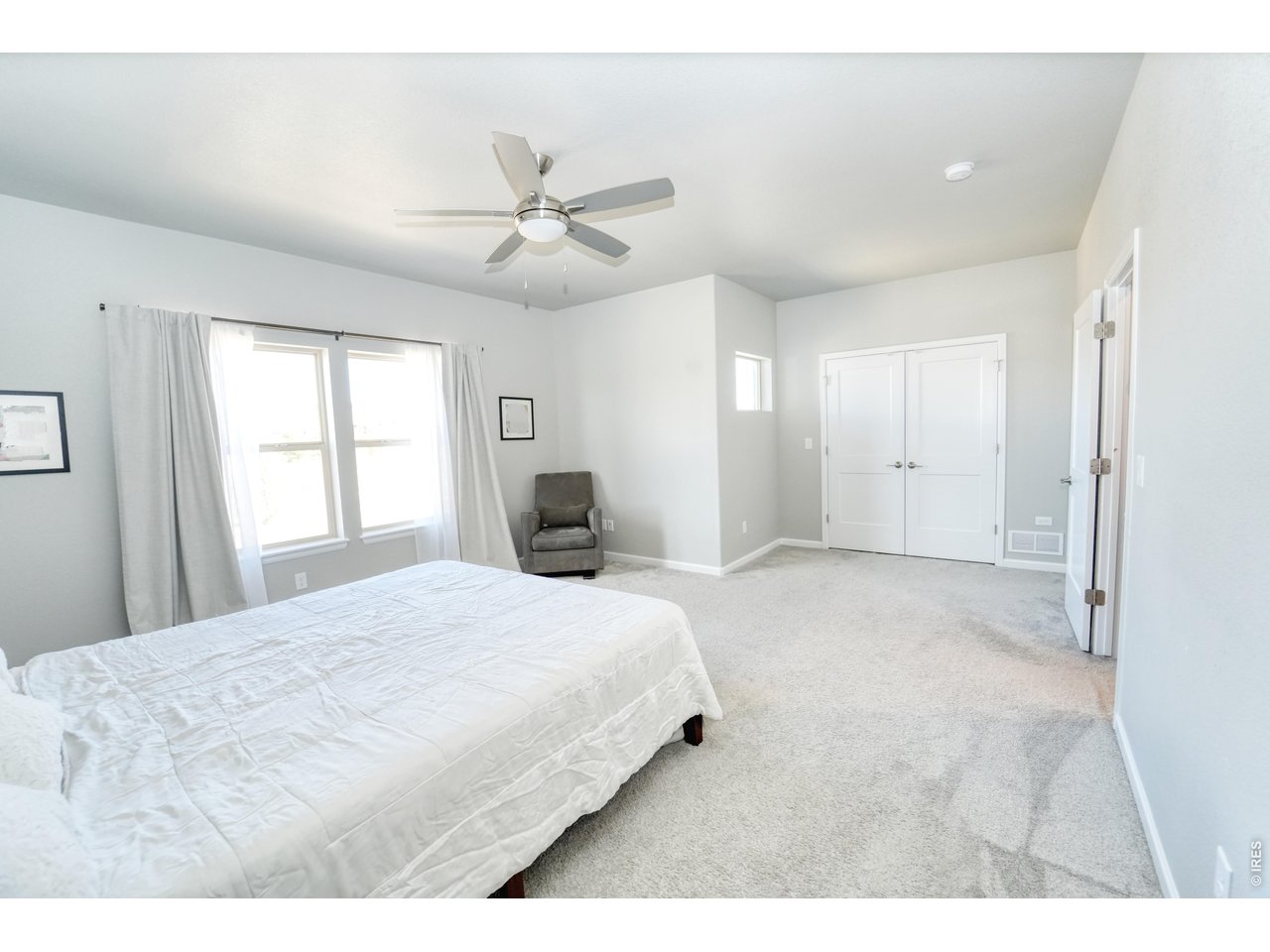 13388 Positano Point Colorado Springs, CO 80921 - Photo 11 of 26 a spacious bedroom with a large bed and a chandelier