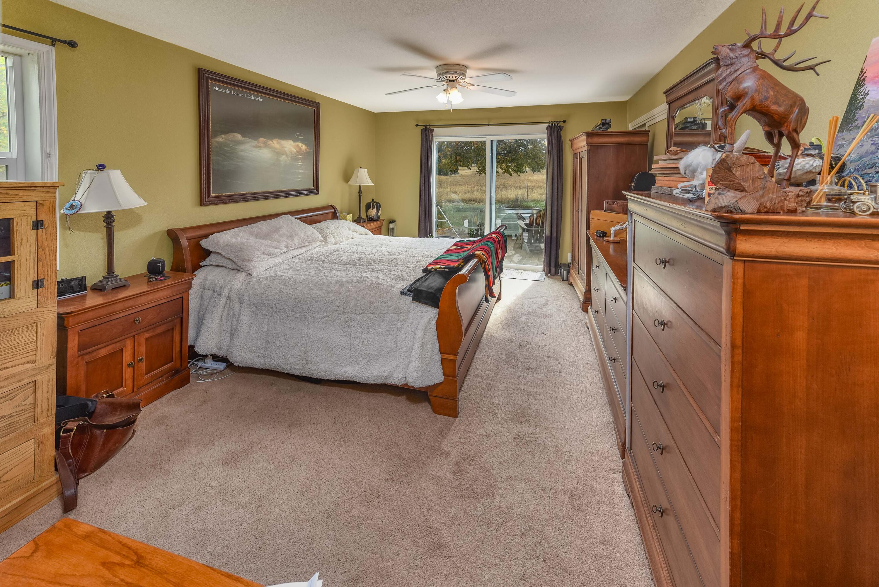 21698 Rickard Road Bend, OR 97702 - Photo 23 of 51 Primary bedroom on the main floor. Has sliding glass doors out to the patio/yard area.