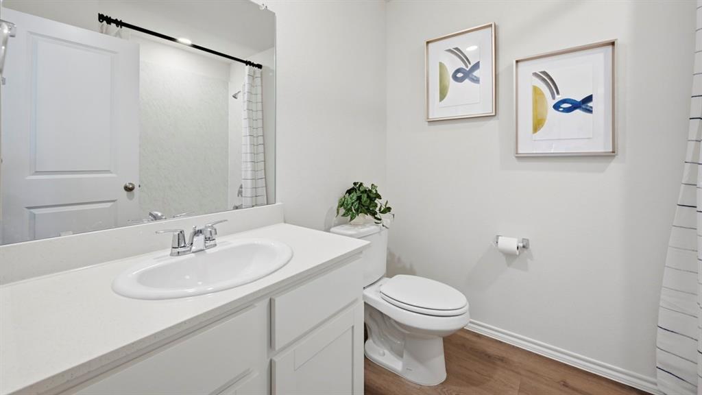 a bathroom with a sink mirror vanity and toilet