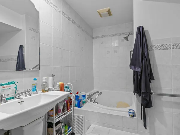 a bathroom with a tub sink vanity and toilet