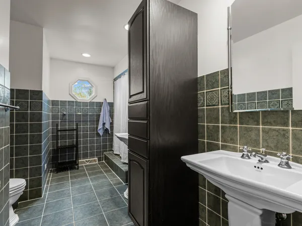 a bathroom with a sink toilet a mirror and shower