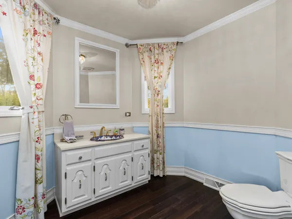 a bathroom with a sink a toilet and a window