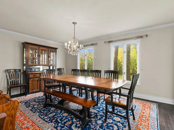 a dining room with furniture a rug and a chandelier