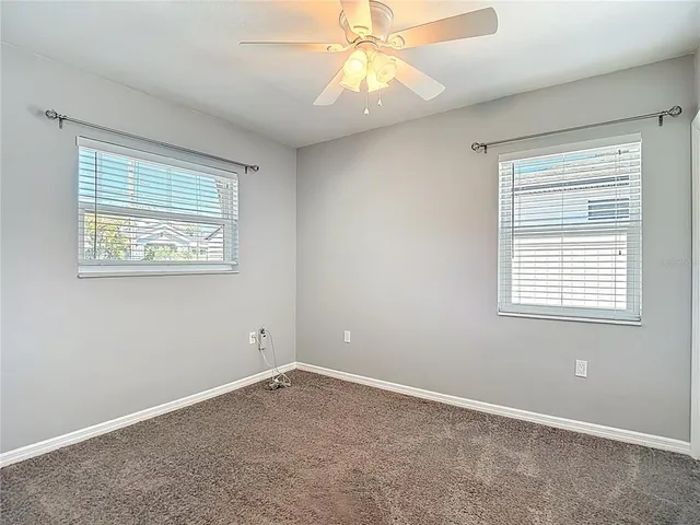 an empty room with a window and a fan