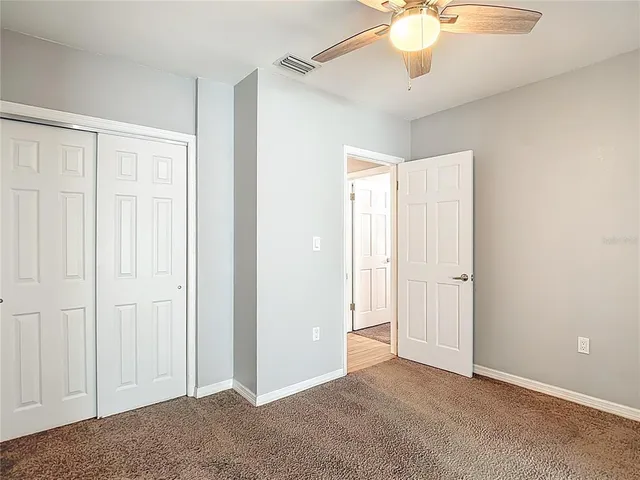 a view of a room with a chandelier fan