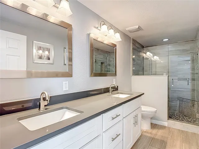 a bathroom with a double vanity sink mirror double and shower
