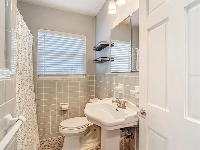 a bathroom with a sink a toilet and shower curtain