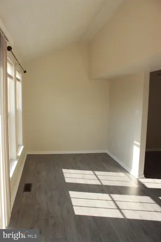 an empty room with wooden floor and sliding door