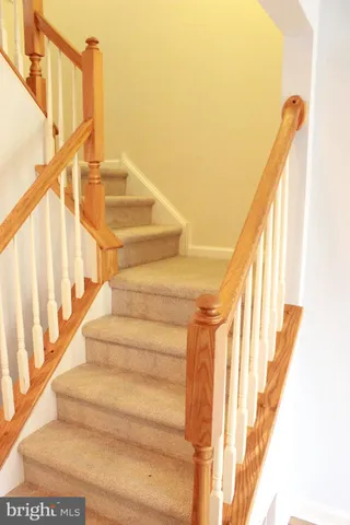 a view of staircase with railing and white walls