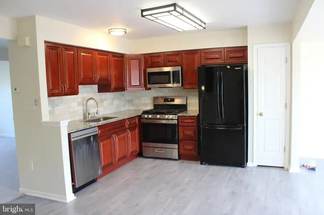 a kitchen with stainless steel appliances granite countertop a refrigerator stove and sink