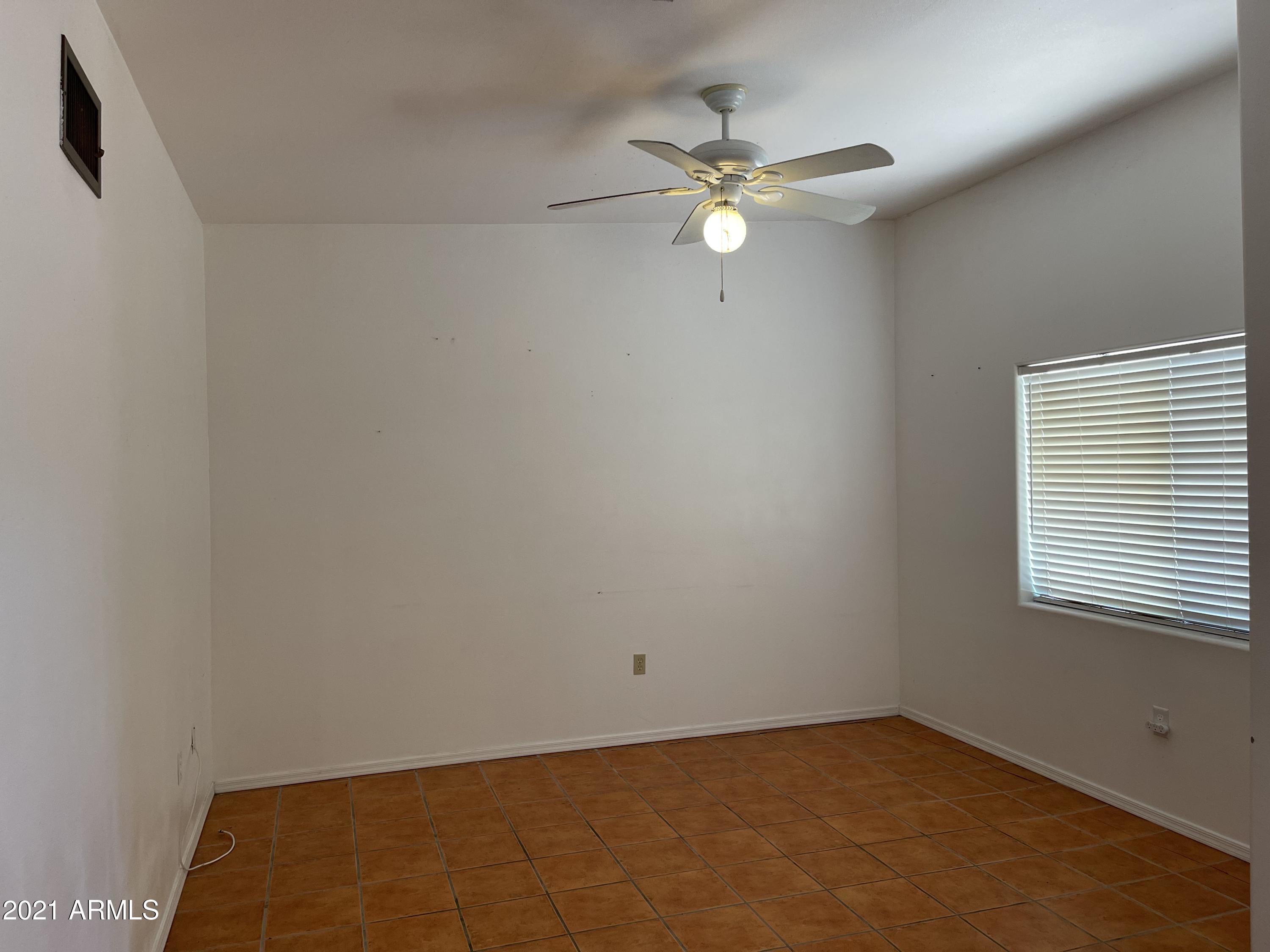 1022 Circulo Golondrina, Unit B Rio Rico, AZ 85648 - Photo 9 of 20 a view of a room with a chandelier fan and a window