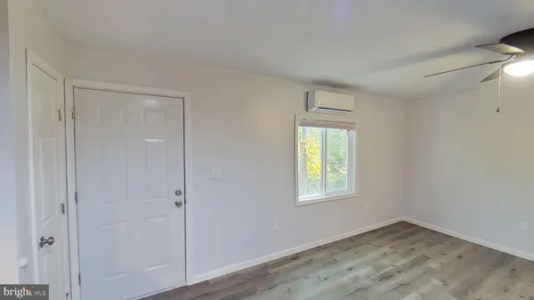 an empty room with wooden floor and a window