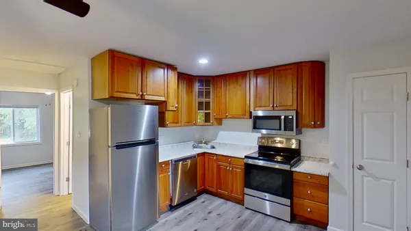 a kitchen with granite countertop wooden cabinets and a stove