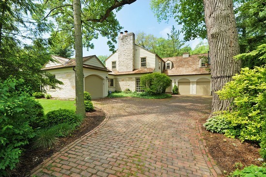 a front view of a house with a garden and trees