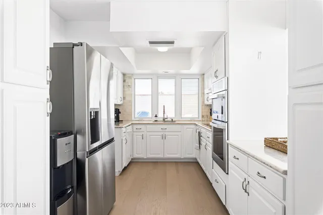 a kitchen with stainless steel appliances a refrigerator sink and cabinets