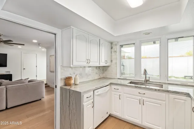 a kitchen with granite countertop white cabinets and a sink