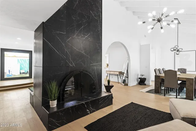 a living room with furniture a fireplace and a chandelier