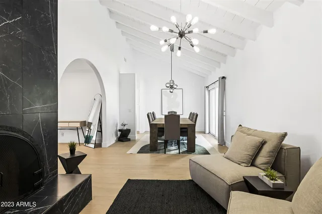 a living room with furniture a fireplace and a chandelier