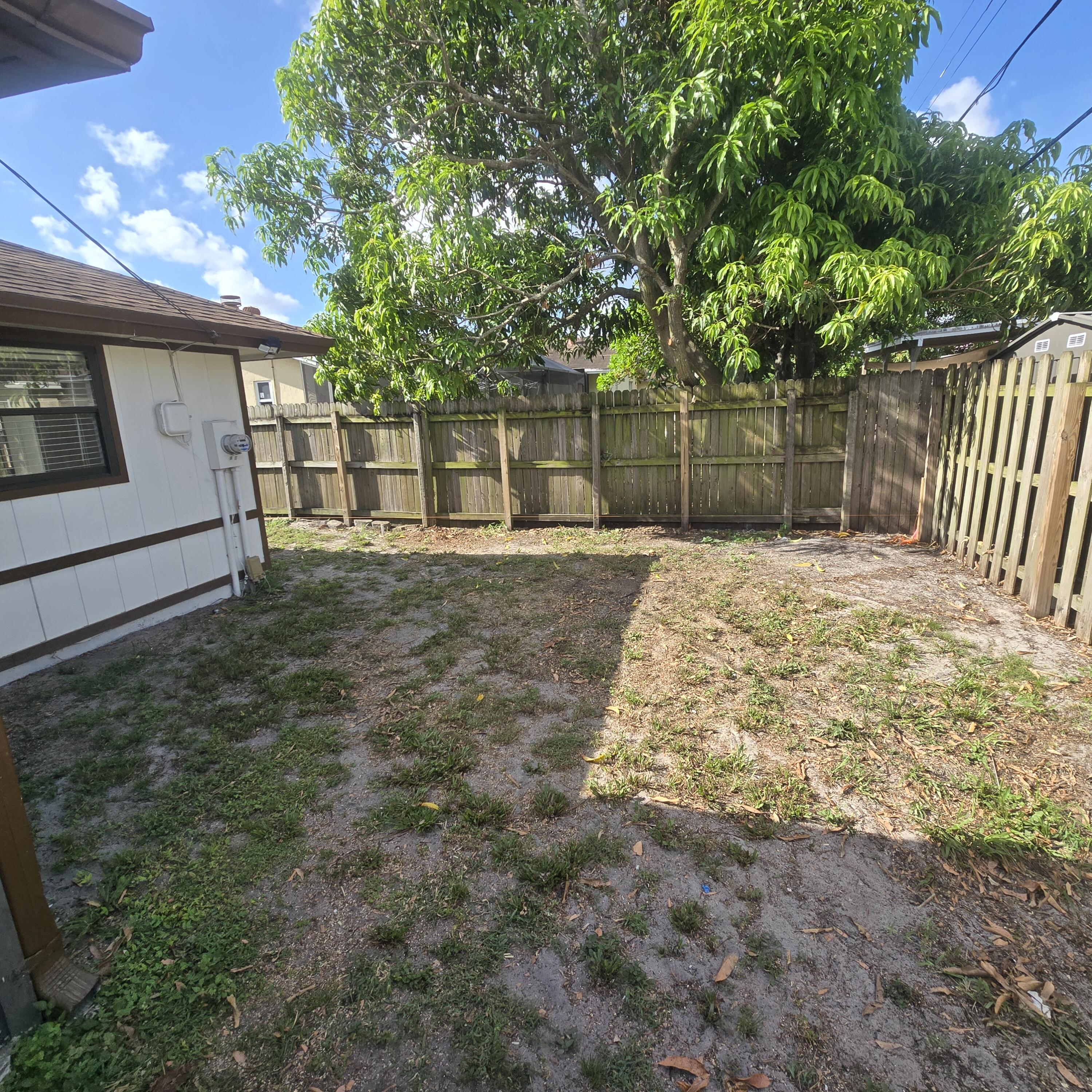 1237 Wynnedale Road, Unit 1237 West Palm Beach, FL 33417 - Photo 16 of 20 a backyard of a house with table and chairs
