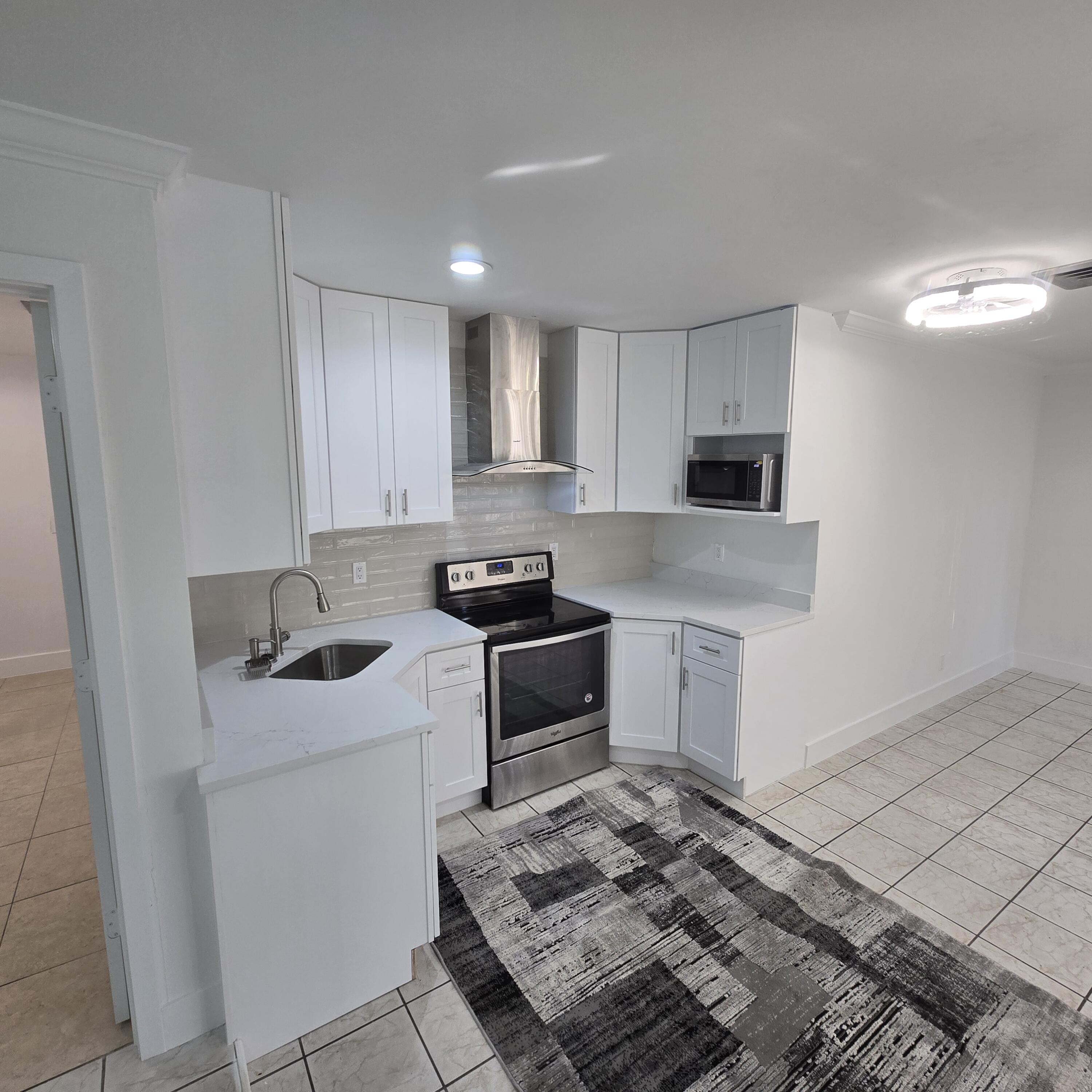1237 Wynnedale Road, Unit 1237 West Palm Beach, FL 33417 - Photo 2 of 20 a kitchen with a stove sink and cabinets