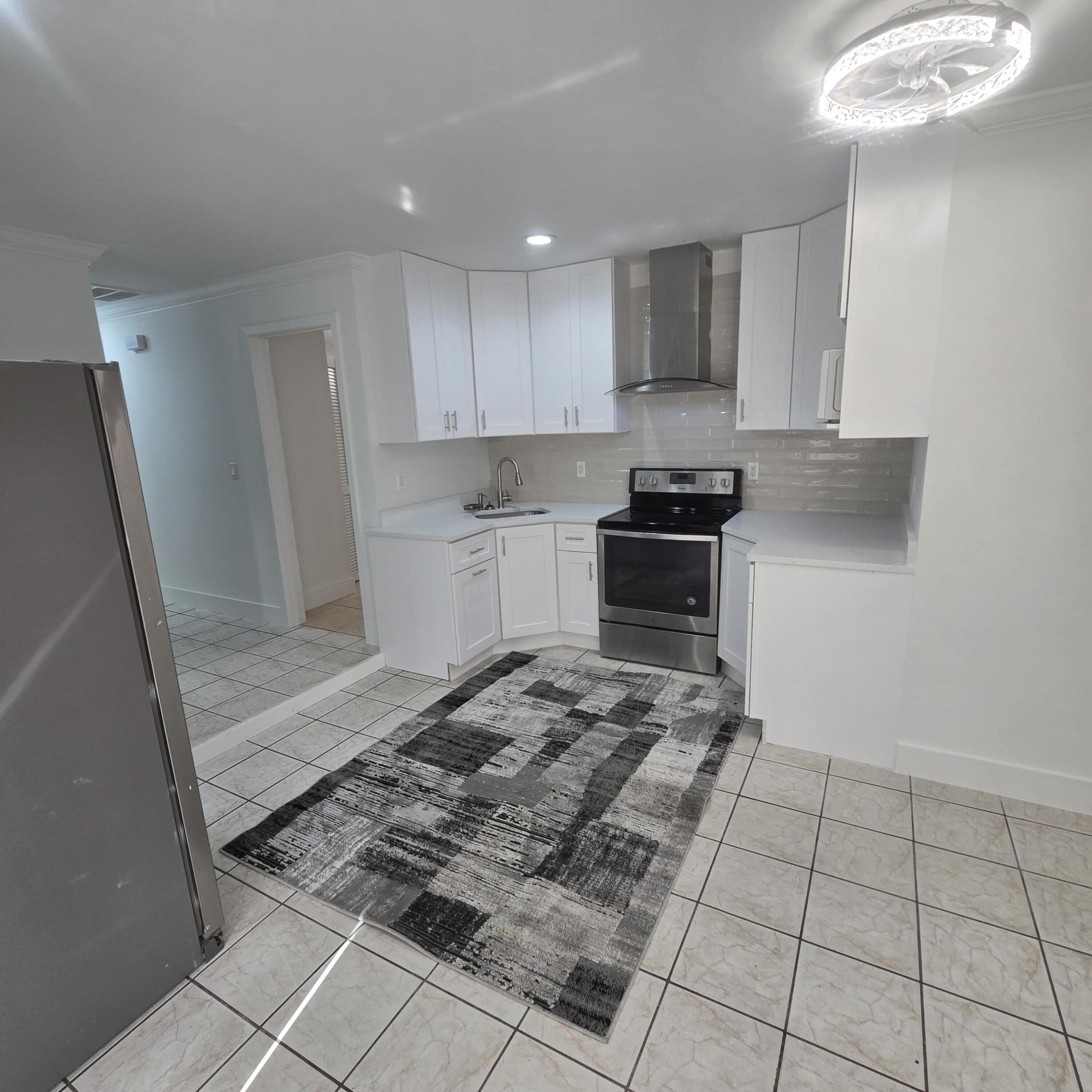 1237 Wynnedale Road, Unit 1237 West Palm Beach, FL 33417 - Photo 7 of 20 a kitchen with granite countertop a stove a sink and a refrigerator