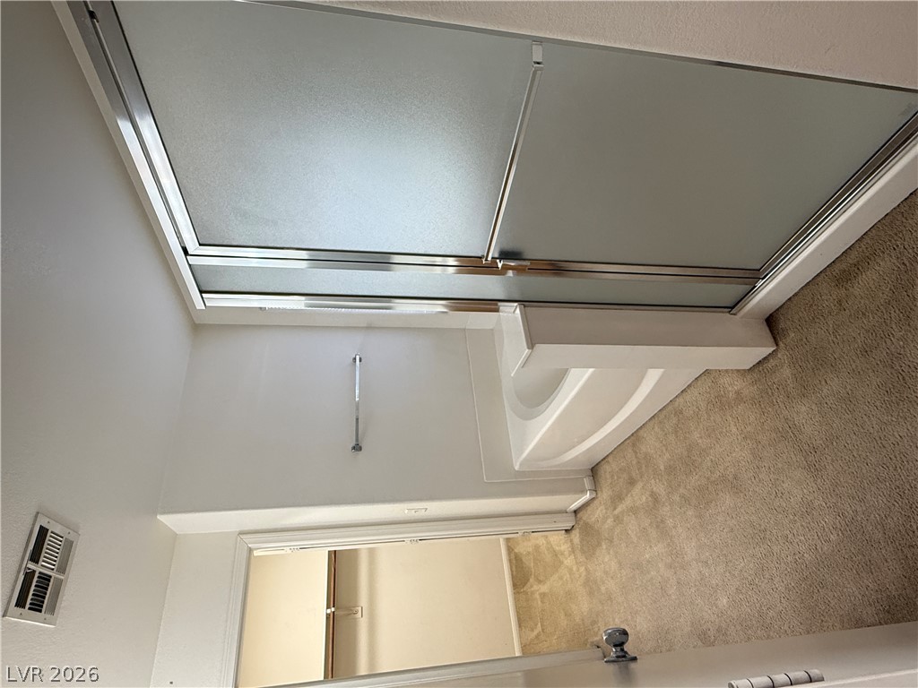 8108 Roundup Ridge Street Las Vegas, NV 89131 - Photo 16 of 21 Step into a refreshing shower featuring frosted glass doors and a pristine white tub surround.