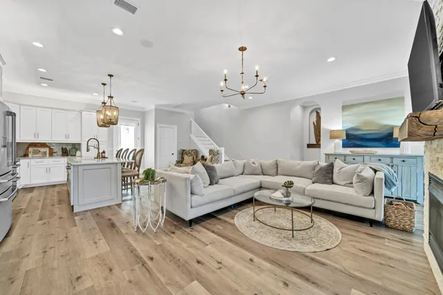 a view of a hallway with wooden floor and a bathroom
