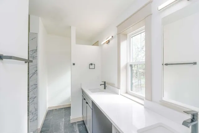 a spacious bathroom with a tub sink and mirror