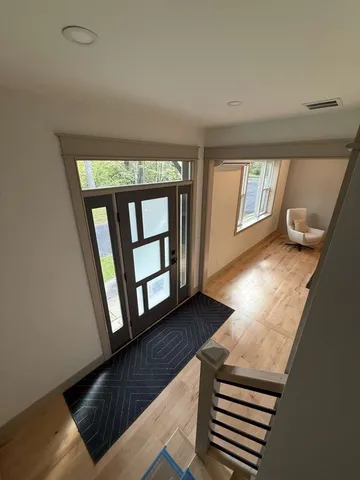 a view of entryway and hall with wooden floor
