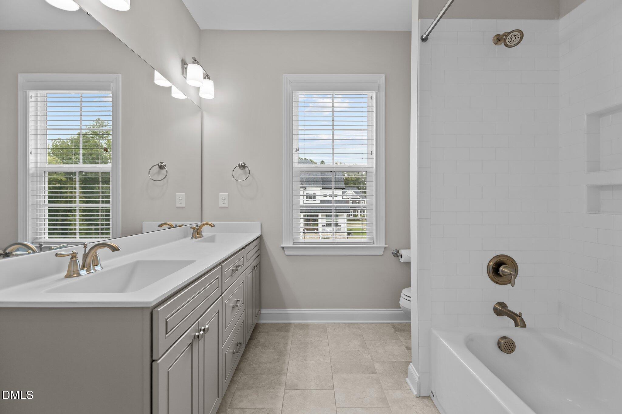 2923 Logan Valley Path Apex, NC 27502 - Photo 16 of 20 a bathroom with a tub sink and mirror