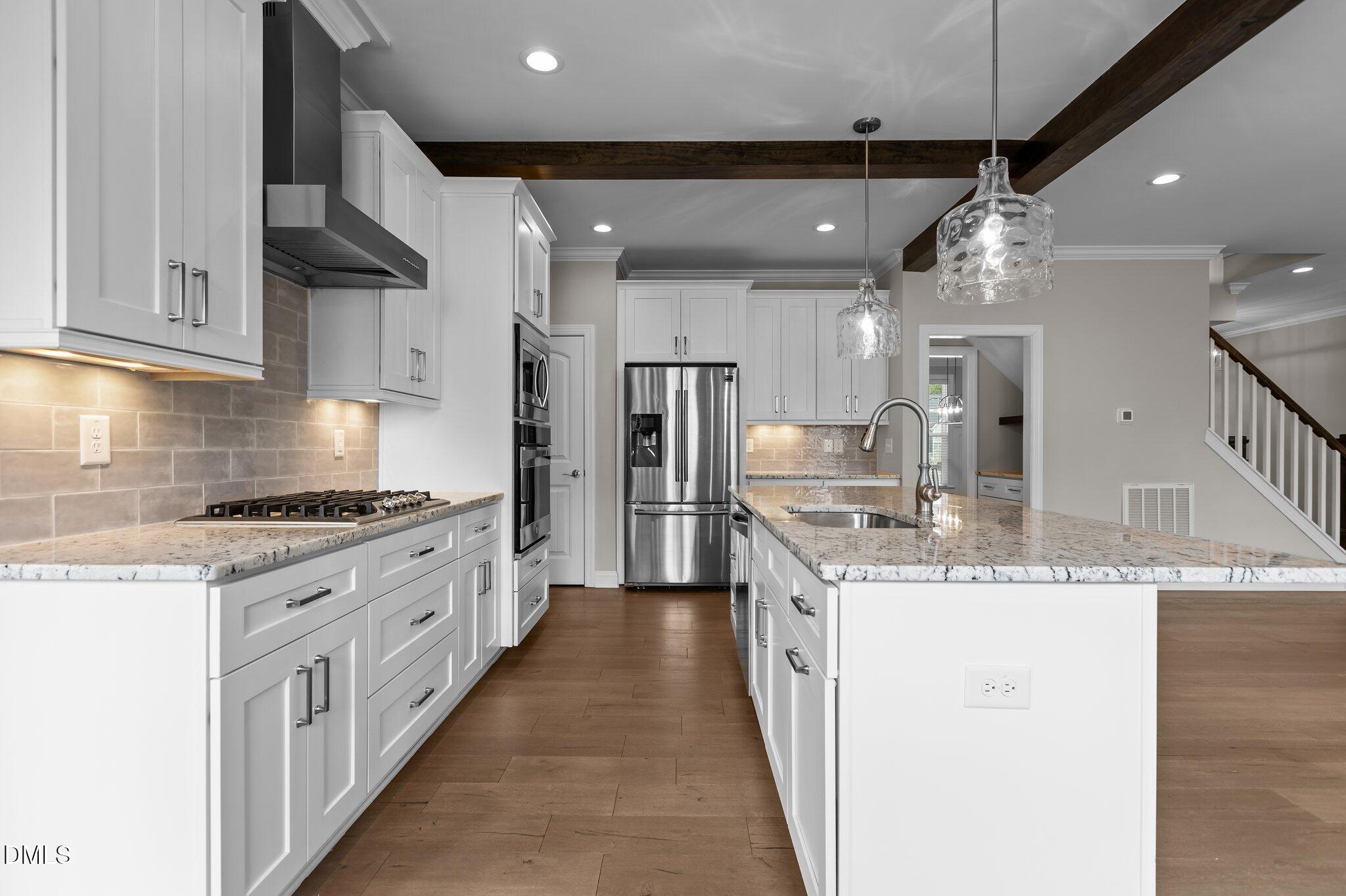 2923 Logan Valley Path Apex, NC 27502 - Photo 6 of 20 a kitchen with stainless steel appliances granite countertop a sink a stove and a refrigerator