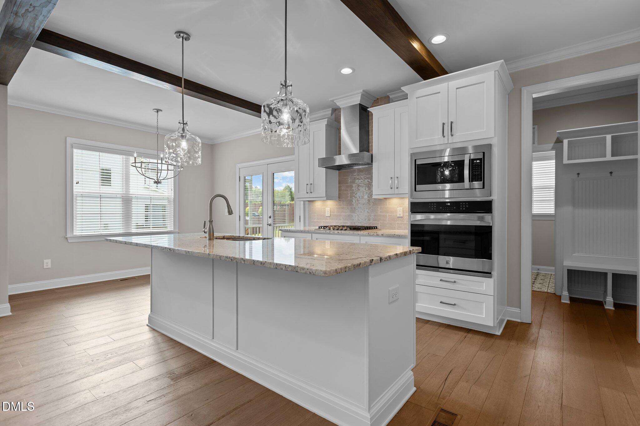 2923 Logan Valley Path Apex, NC 27502 - Photo 8 of 20 a kitchen with stainless steel appliances kitchen island granite countertop a refrigerator a oven a stove and a wooden floors
