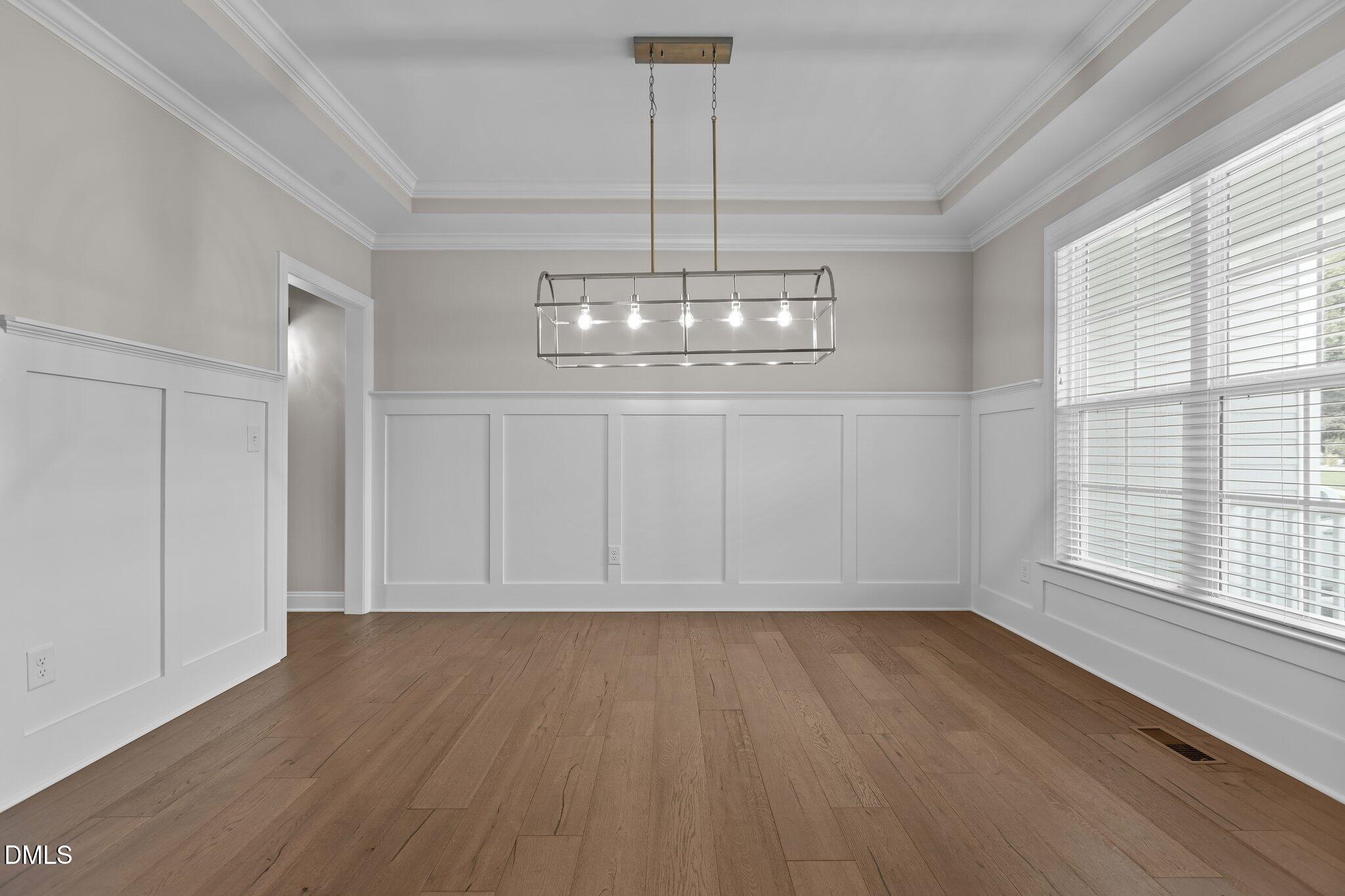 2923 Logan Valley Path Apex, NC 27502 - Photo 9 of 20 a view of an empty room with wooden floor and a window