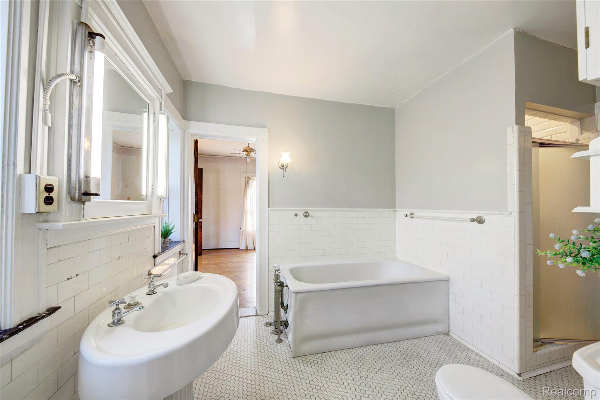 121 Longfellow Street Detroit, MI 48202 - Photo 48 of 87 Bathroom featuring wainscoting, tile walls, a garden tub, a stall shower, and ceiling fan