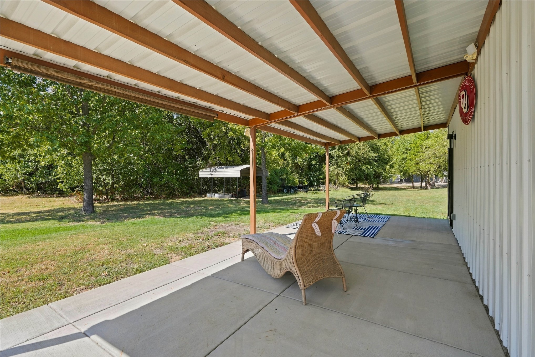 420942 East 1168 Road Eufaula, OK 74432 - Photo 8 of 43 Covered concrete patio with a metal roof supported by wood beams, overlooking a grassy area