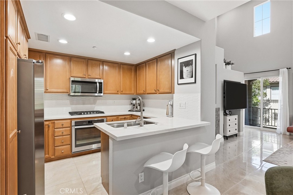 143 Lockford Irvine, CA 92602 - Photo 9 of 43 a kitchen with stainless steel appliances granite countertop a stove top oven a sink dishwasher a dining table and chairs with wooden floor
