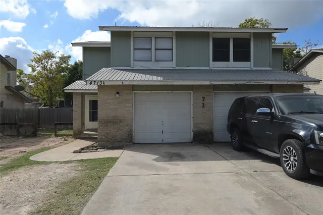 a view of a car parked front of a house