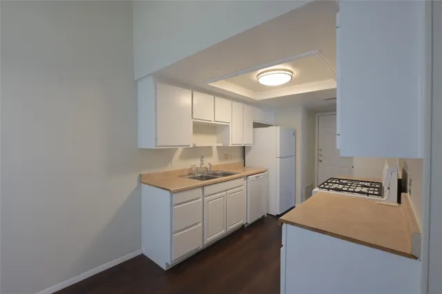 a kitchen with a sink a stove cabinets and a window