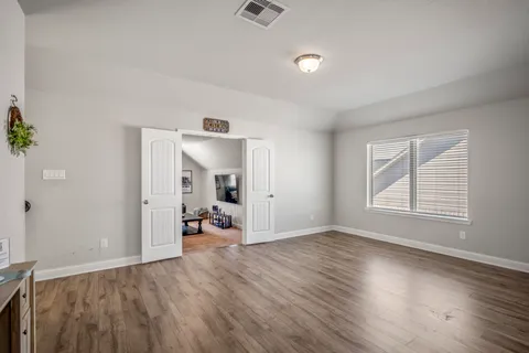a view of a big room with wooden floor and windows
