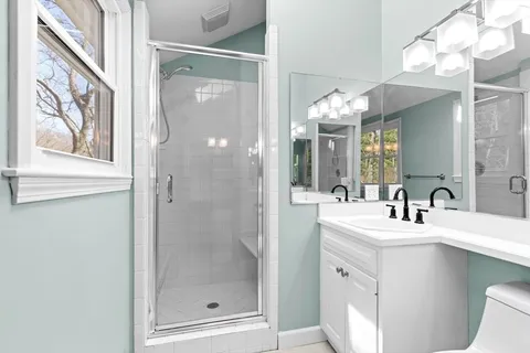 a bathroom with a tub sink and mirror