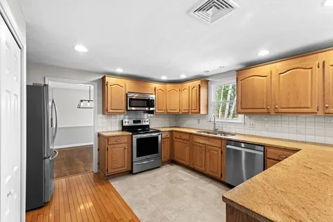 a kitchen with lots of counter top space and view of living room