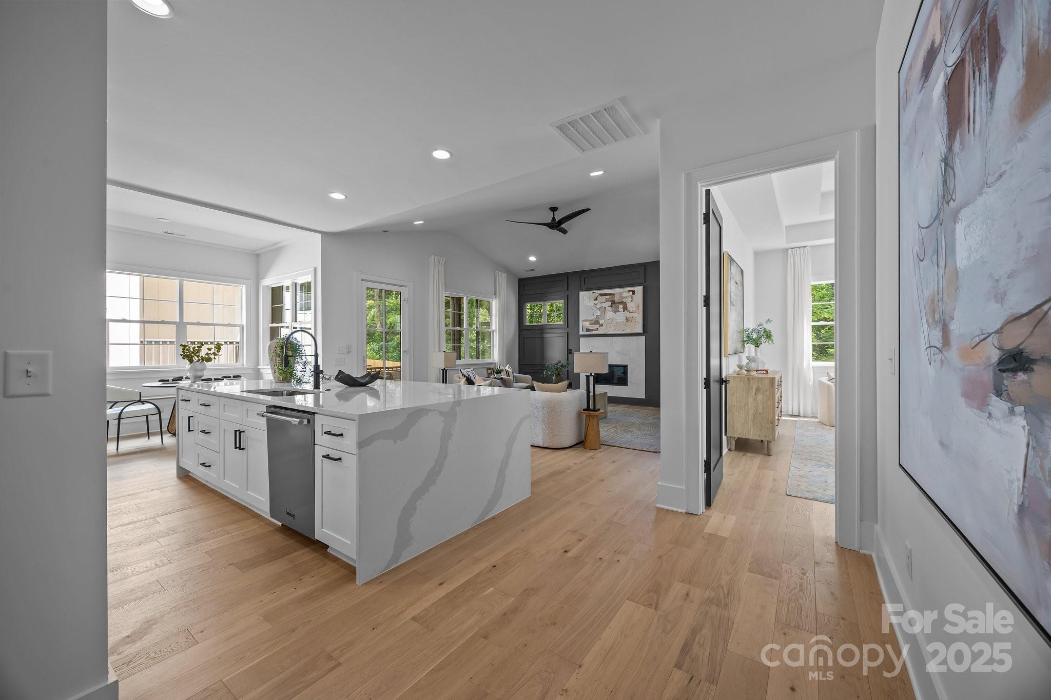 3945 Plainview Road Charlotte, NC 28208 - Photo 19 of 47 a large white room with kitchen island wooden floors stainless steel appliances and windows