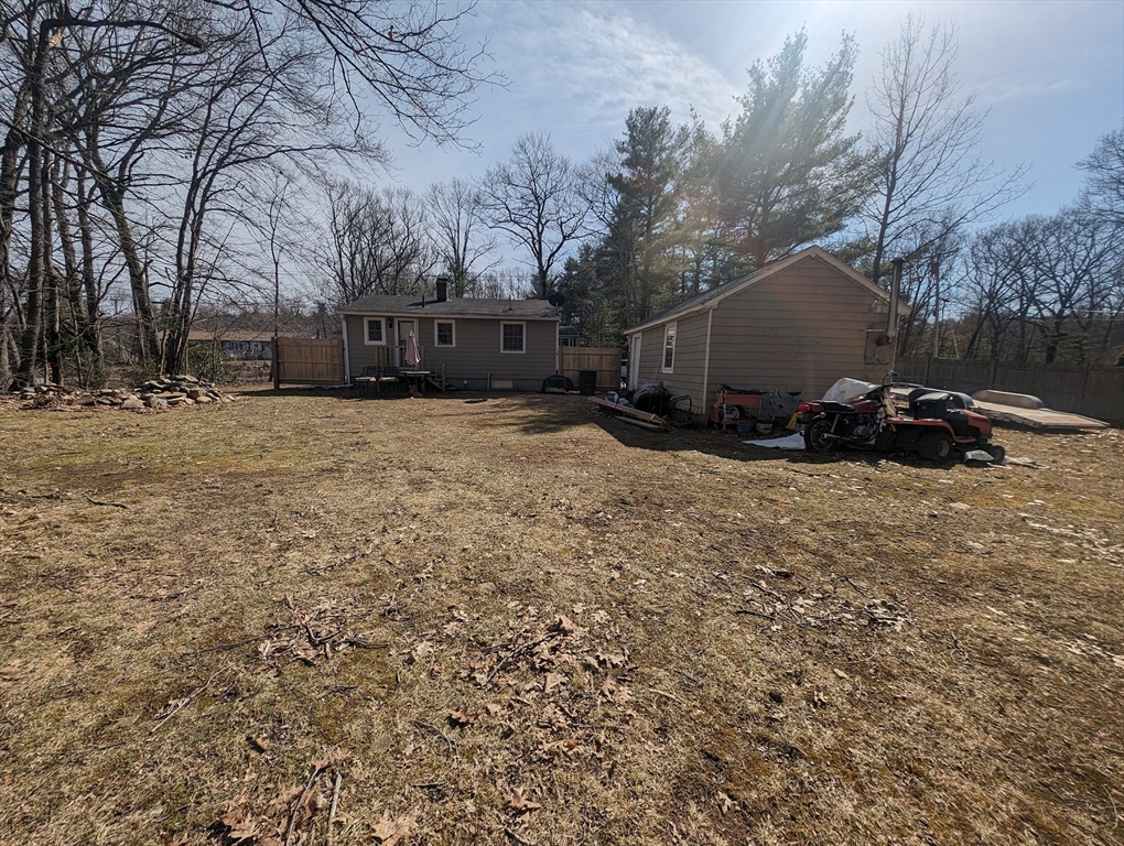 138 Old Worcester Road Charlton, MA 01507 - Photo 3 of 33 a backyard of a house with fire pit and trees