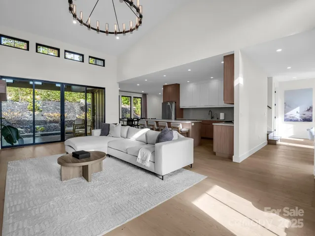 a living room with furniture a chandelier and a fireplace