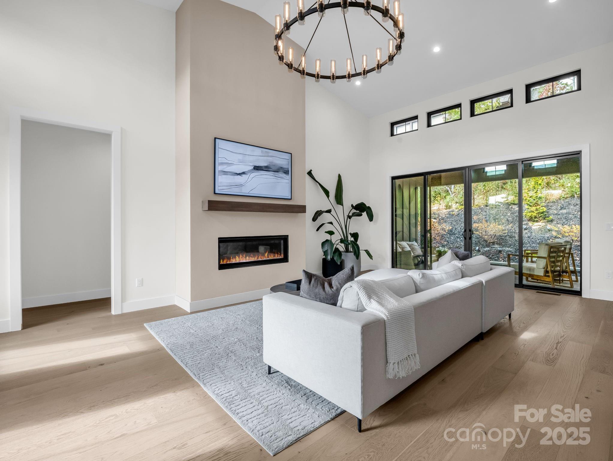 123 Millbrae Loop Hendersonville, NC 28791 - Photo 15 of 48 a living room with furniture a chandelier and a fireplace