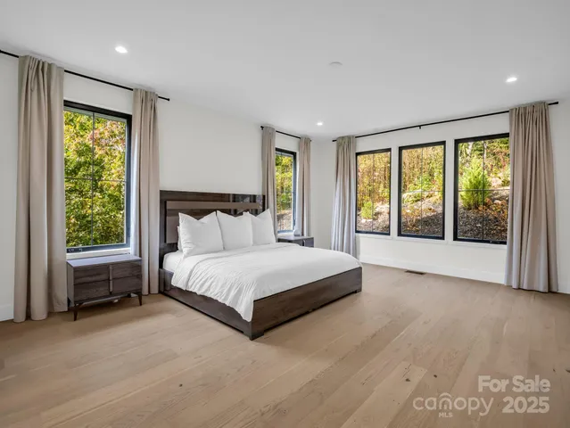 a spacious bedroom with a bed and a large window