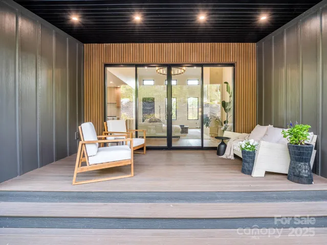 a living room with furniture and floor to ceiling window